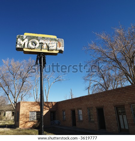 Rundown motel building with blue sky in background.