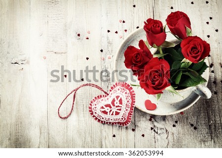 St Valentine's setting with bouquet of red roses in retro mug. Copy space