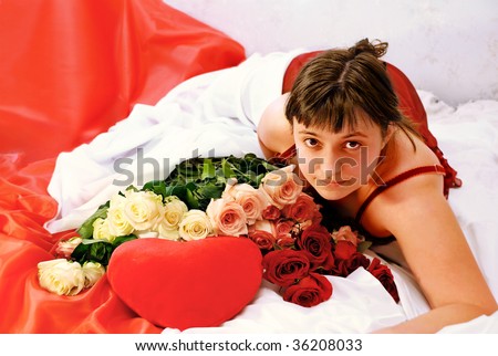 Girl, lying on beds, heart and roses with it alongside.