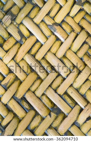 Detail close up view of a uniform golden woven basket using natural branch materials.Pattern of Thai style bamboo handcraft texture background 