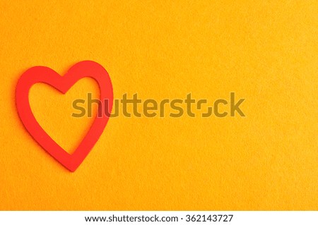 Valentine's Day. A red heart isolated against a orange background