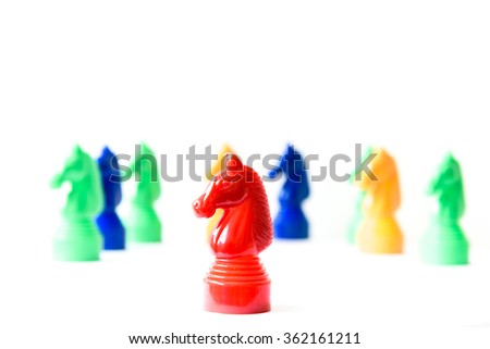 Close up view of a red horse is following by other ones in a horse race (board game) isolated on white. Concept of leadership, teamwork, business strategy, and influence. Stand out from crowd abstract