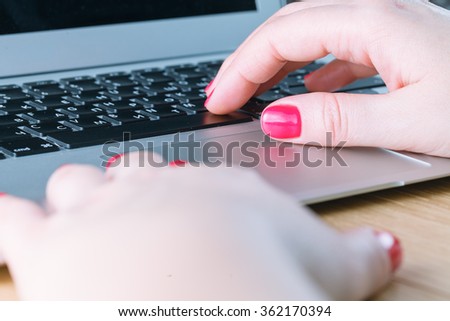 Closeup of woman hand typing on laptop keyboard