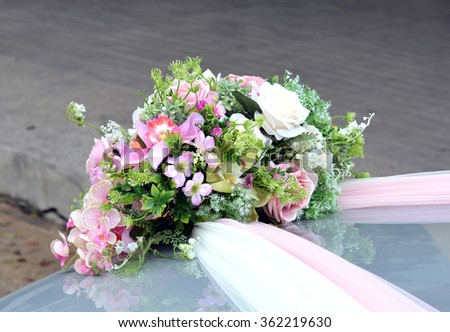 Rose artificial flowers bouquet on the bonnet car - wedding ceremony