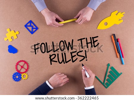 Business Team with a phrase FOLLOW THE RULES!