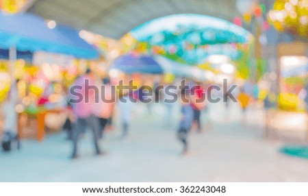 Blurred image of people walking at day market in sunny day, blur background with bokeh .