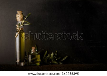 Extra virgin olive oil two glass bottles on black chalkboard background Royalty-Free Stock Photo #362256395