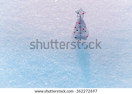 Decorative Christmas tree in the snow. Holidays greetings concept.