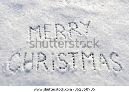 Written words Merry christmas on a snow field, new year concept. Cool Blue filter applied.