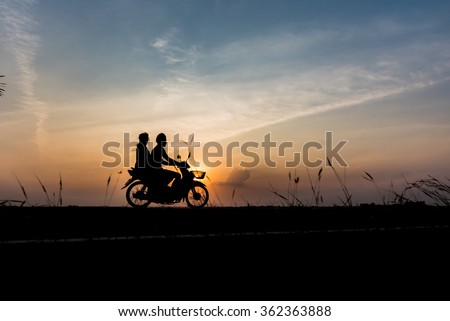 Silhouette of the husband and wife while driving home from work in the evening . Royalty-Free Stock Photo #362363888