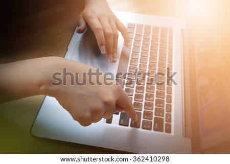 Closed up point finger of business woman press key enter with her laptop. abstract art, success and business concept with technique lens flare and warm tone in blank space.