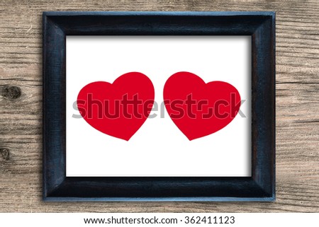 Red heart in photo frame on wooden background , valentine concept