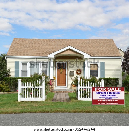 Beautiful Suburban Bungalow Cottage style home with white picket fence flowers residential neighborhood Blue Sky Clouds USA