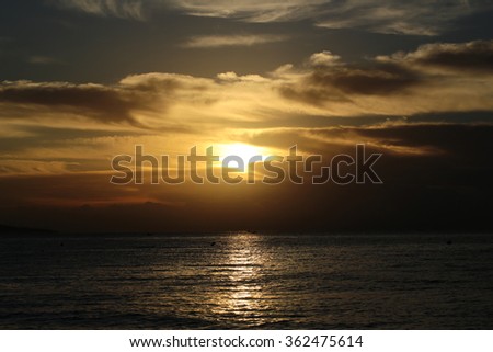 Photo of spectacular marine seashore dark blue sea with ripples against yellow-light illumination of low level cloudy grey sky at sunset dusk bleakness over seascape background, horizontal picture