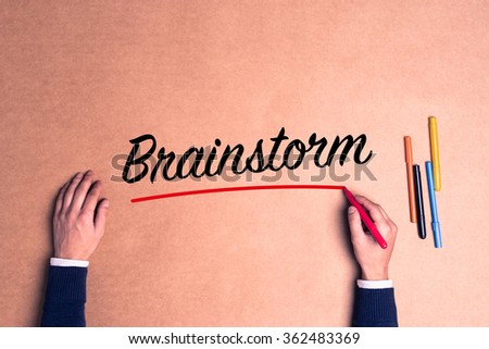 Hand writing a single word Brainstorm on paper