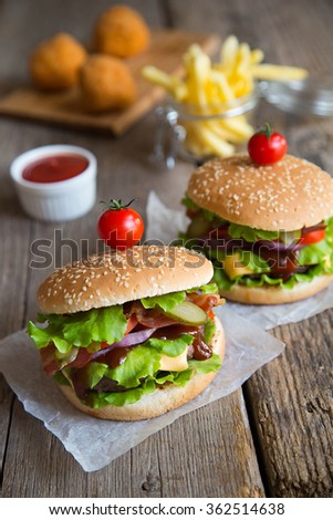 Two hamburgers with fries, ketchup and fried balls