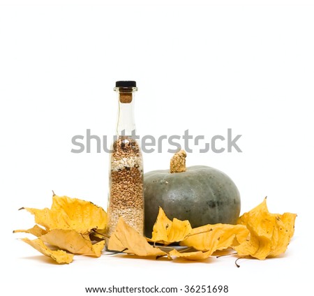 Pumpkin and bottle with groats on fall leafs isolated on white