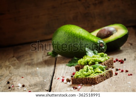 Sandwiches with black rye bread and avocado mousse with spices, selective focus