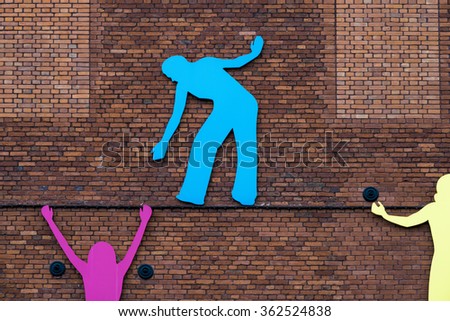 Abstract silhouette of people helping each other while climbing wall