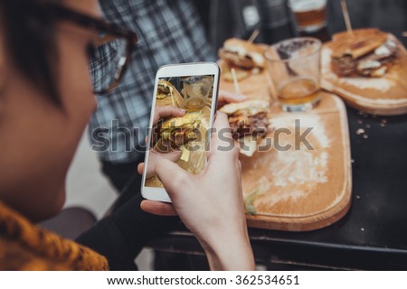 Close Up Of Woman Taking Picture Of  Delicious Burger Using Smart Phone