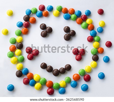 colorful smiley, kind, happy emotional candy face  with blushes on white background made of round candies for children games looks like Kapitoshka