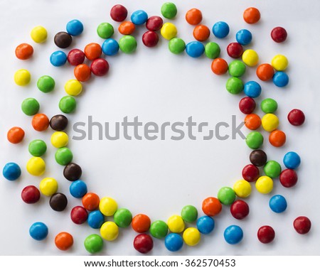 Round frame look like sun of colorful chocolate candies on a white background with space for your text Valentines Day concept