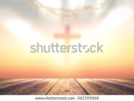Funeral concept: Wooden table with the cross of Jesus Christ on sunset background