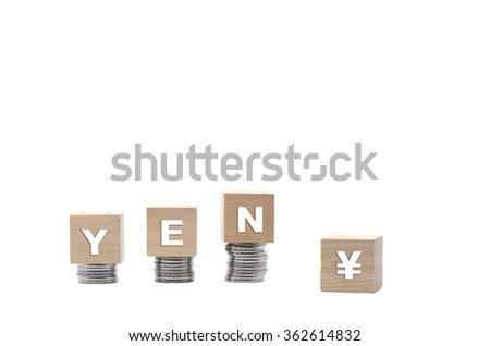 Monetary units : YEN text written on wooden block with stacked coins isolated on white background