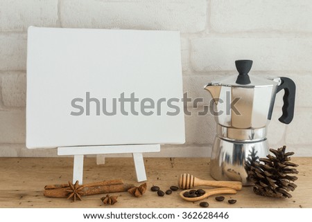 Blank white wooden easel  blank canvas and coffee set on wooden table with white wallpaper background for your text