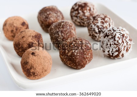 Homemade natural vegan chocolate truffle with cacao on white square plate on white background