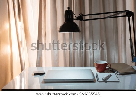 The computer is on the work table in a Home office with morning light and vintage tone.