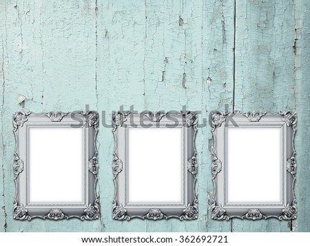 Close-up of three silver Baroque picture frames on weathered aqua wooden background