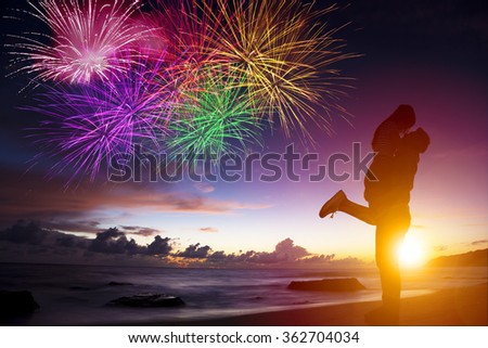 sunset silhouette of young couple in love hugging on beach