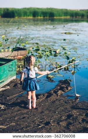 little girls fishing on lake at summer