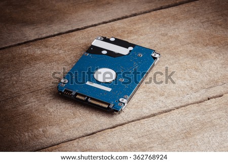 slim harddisk storage is storage data for computer on wooden table. Close up Connector Pin of harddisk drive