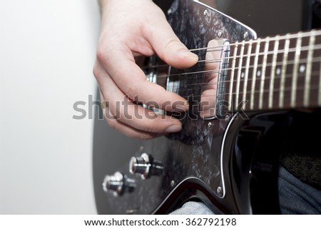 Detail picture of man's hand on the electric guitar