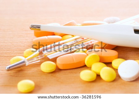 Thermometer and pills, abstract medical background