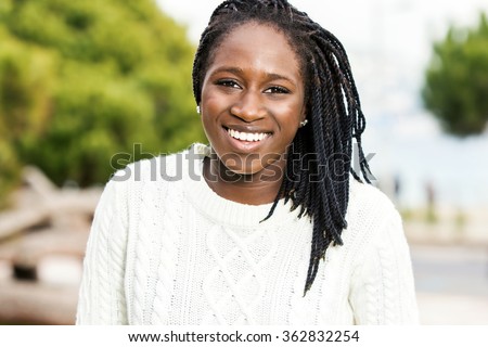 Close up outdoor portrait of attractive african teen girl with braided hairstyle.