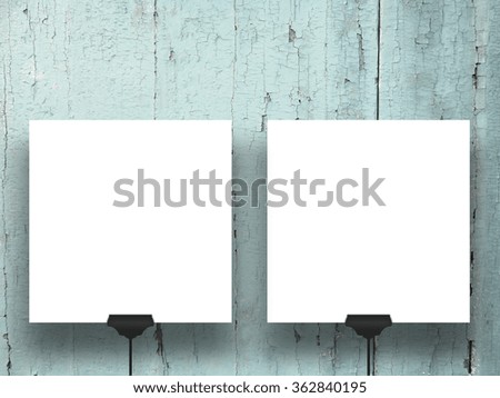 Close-up of two square paper sheets with clips on aqua wooden boards background