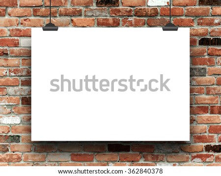 Blank poster frame with clips on multicoloured brick wall background