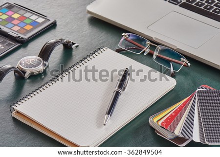 modern working table top view close up of businessman or designer or architect or manager with notebook, color checker, pen, watch, laptop and glasses on leather table with copy space mock up.