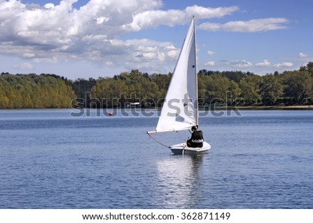 Small white boat sailing on the lake 