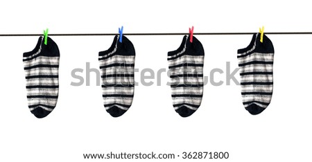 4 Striped socks hanging on colorful washing clips on clothes rope