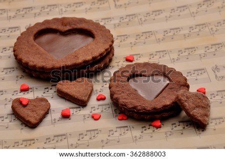 Chocolate chip cookies in the shape of a heart with toffee, on a decorative background musical notes.