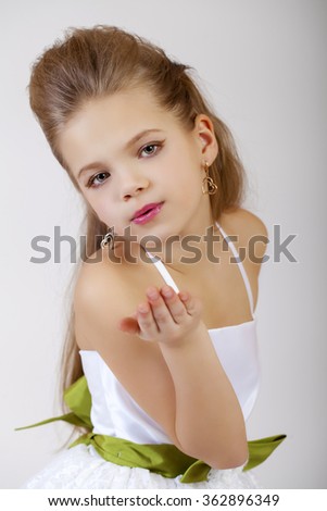 Portrait of a little girl in white classic dress, isolated on gray background