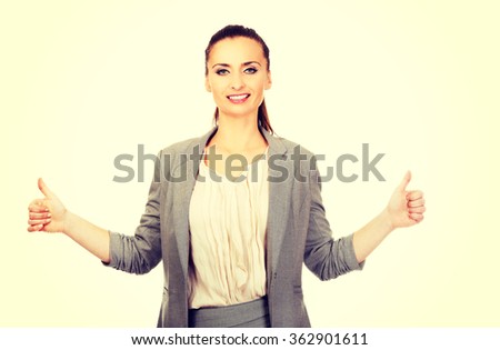 Smiling businesswoman with thumbs up.