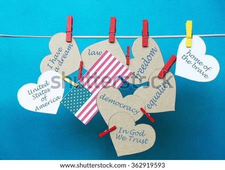 White hearts - room for text, USA flag hanging on colorful pegs, clothespin  on a line. United States of America holidays info. Martin Luther King Day, National Freedom Day, Abraham Lincoln day.