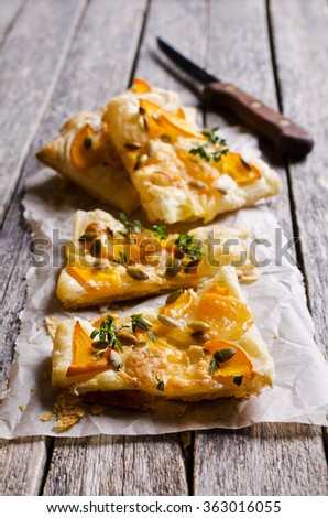 Tart with pumpkin and cheese on wooden background. Selective focus.