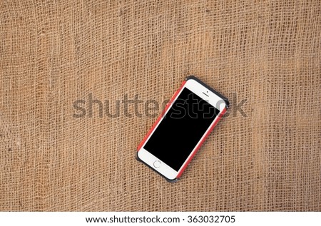 Phone on burlap for background.