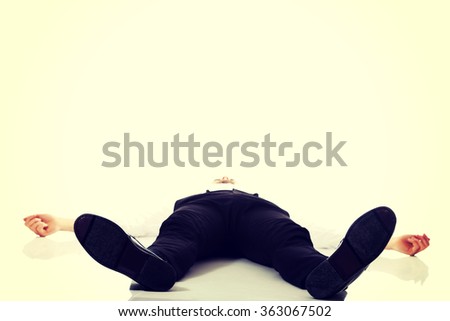 Exhausted businessman lying on the floor.